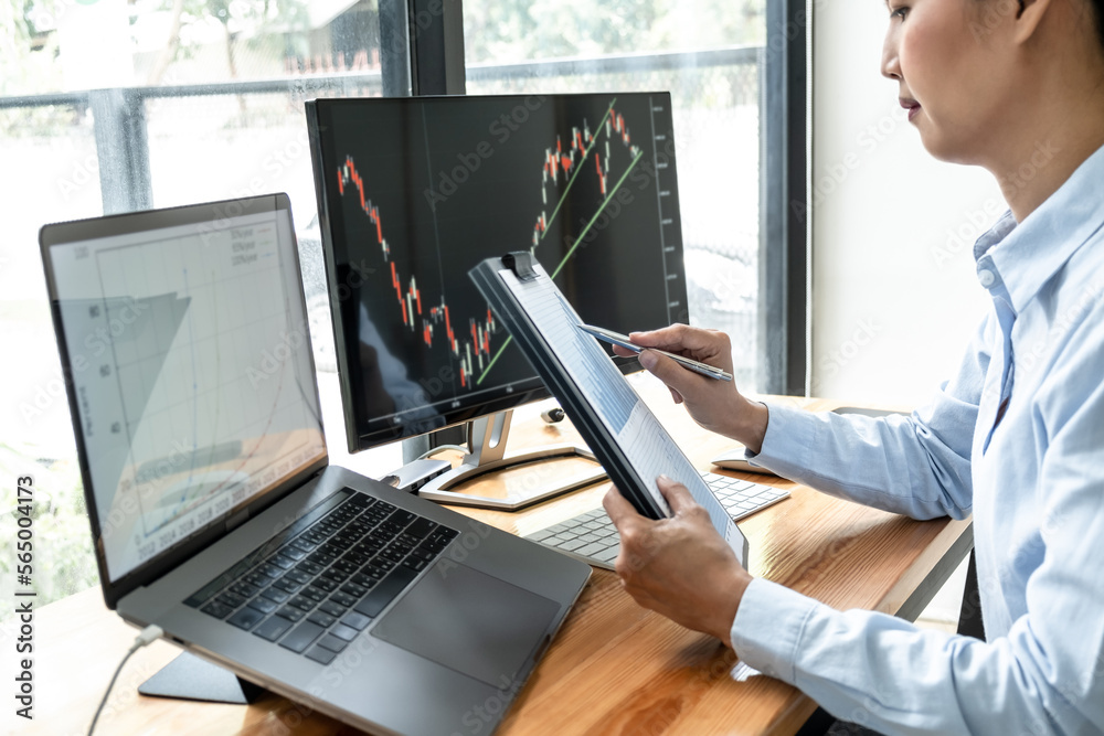Poster Businesswoman investor having planning and analyzing graph data with display screen the data presented and deal on a stock exchange