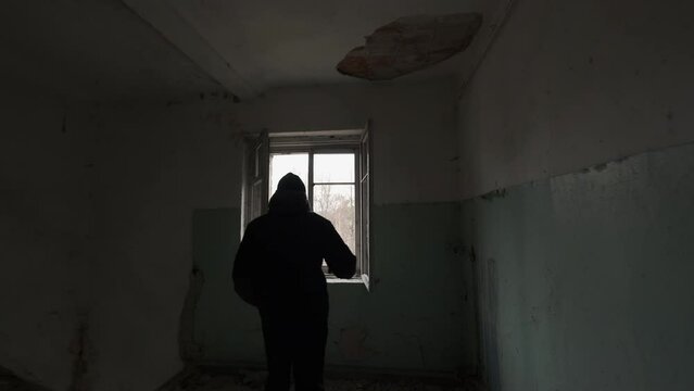 Silhouette of man entering room in forsaken building