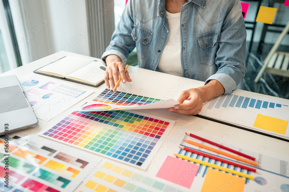 Aufkleber Young creative graphic designer working on color selection and drawing on graphics tablet at workplace, Color swatch samples chart for selection coloring in inspiration to create new collection