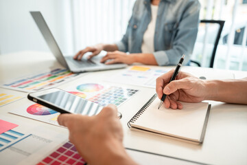 Team of creative graphic designer working on color swatch samples chart for selection coloring in inspiration to create new collection at workplace