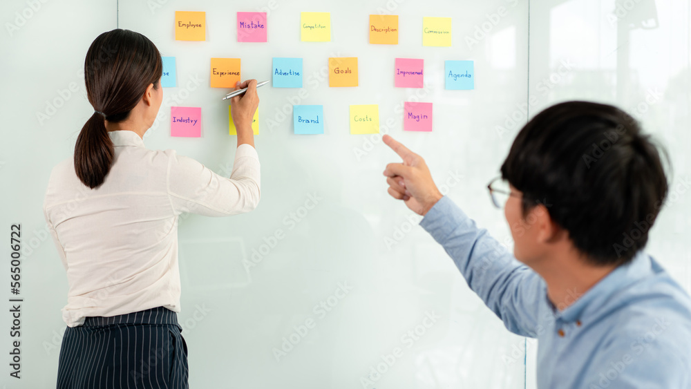 Poster two business executive team holding and taking notes keyword on board wall to brainstorm about a new
