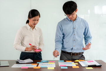 Business executive team brainstorm and takes notes on keyword about a new business project for...
