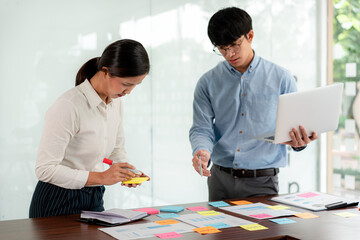 Business executive team brainstorm and takes notes on keyword about a new business project for...