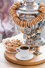 Russian traditions. Tea drinking with a samovar. Still life with bagels, bagels and Russian samovars in the interior of a modern living room. Russian culture.