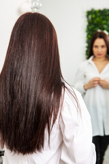 Fototapeta premium Beautiful young woman with long black hair in a beauty salon.