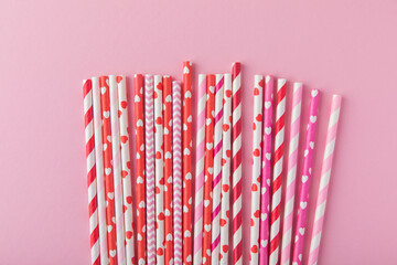 Drinking straws for Valentine's day. Red, pink and white party paper drinking straws on pink background