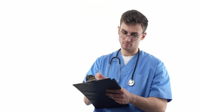 A young doctor in uniform and with a stethoscope writes annotations in a notebook. The concept of development of young professionals in world medicine.