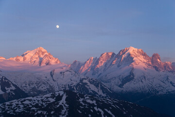 The full moon over the Mont Blanc range at sunset in the French Alps.