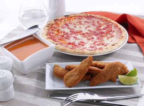 Pechugas de polo empanadas y pizza de jam&oacute;n y queso. Breaded polo breasts and ham and cheese pizza.