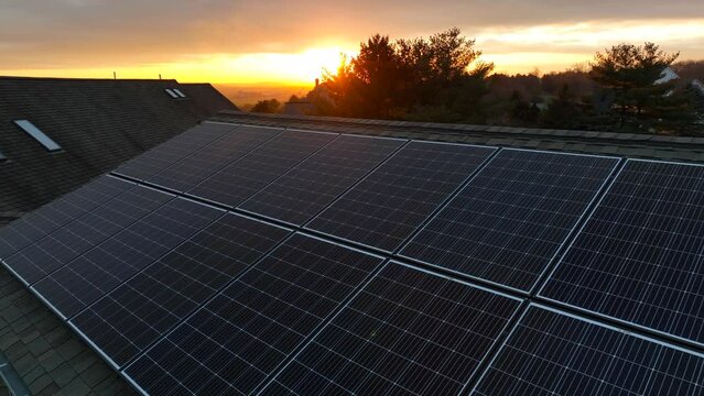 Solar panels on roof of house in America during winter sunset. Aerial view of photovoltaic solar cells.