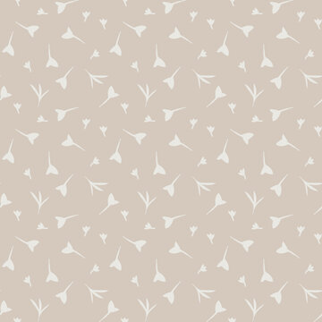 Seamless ditsy pattern of small flowers or leaves on a beigh backchourn
