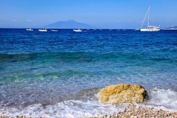 Capri beach and coastline with boats and sailboats, amalfi coast, Italy