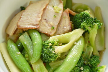 stir fried broccoli with green pea in oyster sauce topping slice grilled pork on bowl