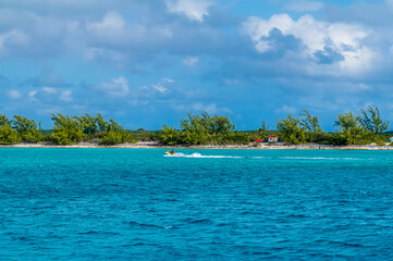 A view towards the tree lined coastline on the island of Eleuthera, Bahamas on a bright sunny day