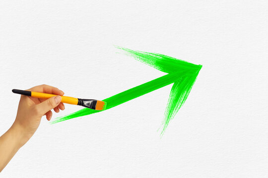 Hand Drawing An Upward Green Arrow On White Paper Background