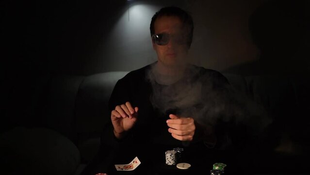 Bearded man plays poker in a casino. The person wins and effectively throws the cards on the table. Slow motion.