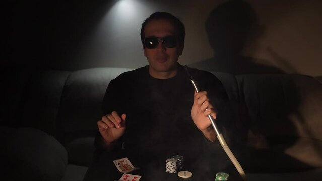 Bearded man plays poker in a casino. The person wins and effectively throws the cards on the table. Slow motion.