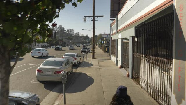 Hipster girl walking down sidewalk in urban area, dolly crane shot