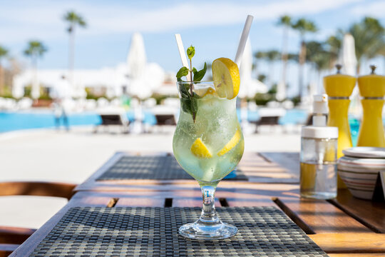 Mohito Fresh Cold Cocktail On The Wooden Table With Eco Paper Straw In The All Inclusive Hotel Near The Swimming Pool