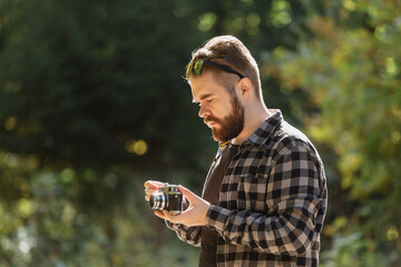 Portrait man photographer taking picture with vintage camera on city green park copy space and place for text - leisure activity and hobby concept