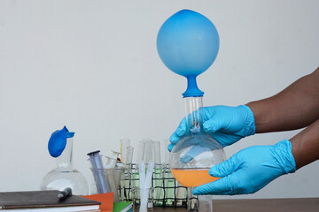 Student do science experiment, lab lesson, transparent bottles with inflated balloons on top of...