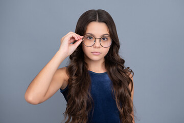 Cute school girl wearing glasses on yellow studio background, smart clever schooler girl in eyeglasses. Nerd student, genius schoolgirl, School, education concept.