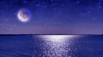 Fototapeta na wymiar night sea at sunset cloudy starry sky sun light and big moon reflection on water waves nature 