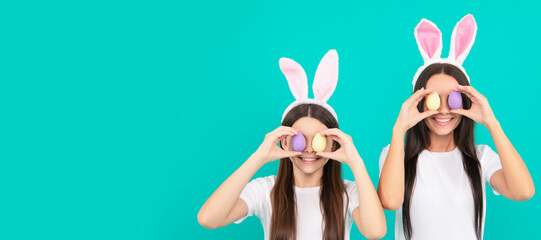 Mother and daughter child banner, copy space, isolated background. funny easter family of mother and daughter in bunny ears hold painted eggs, easter egg hunt.
