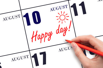 Hand writing the text HAPPY DAY and drawing the sun on the calendar date August 10