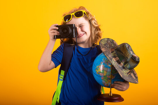 Travel and adventure concept. Little child boy tourist explorer with globe world. Discovery, exploring and education. Studio isolated portrait.