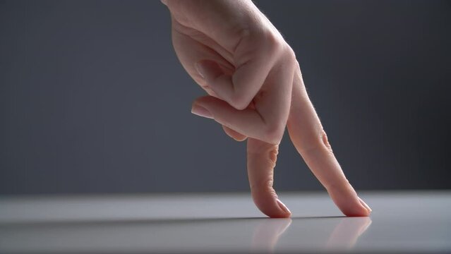 Silly figures of a body as a parody of human legs. Female hand walking on a surface with pointer and middle fingers. High quality 4k footage