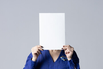 Woman covering her face with a white poster