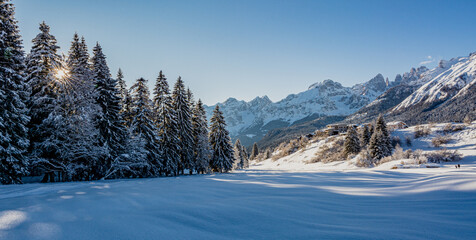 Fototapeta na wymiar Beautiful winter mountain snow-covered landscape on sunny day. Andalo village, Adamello Brenta Natural Park, Trentino Alto Adige, northern Italy, Europe