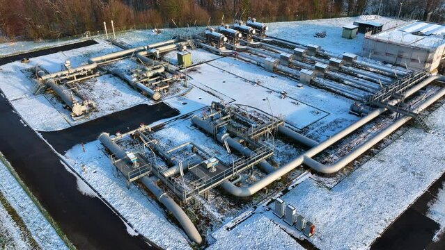 Gas pipeline operational plant at Wallbach Switzerland in snow, drone down pedestal tilting shot