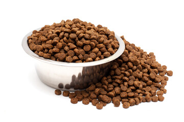 A bowl of dry cat food isolated on a white background. Food scattered nearby