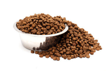 A bowl of dry cat food isolated on a white background. Food scattered nearby