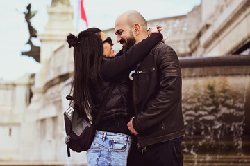 Happy  Tourists  couple traveling at Rome, Italy, poses in front of Altar of the Fatherland (Altare della Patria) and Piazza Venezia at, Rome, Italy