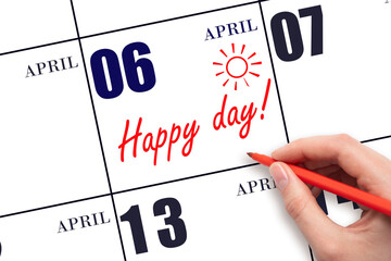 Hand writing the text HAPPY DAY and drawing the sun on the calendar date April 6