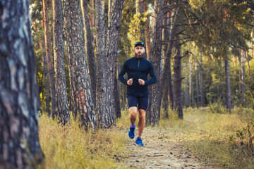 A bearded athlete runs along a picturesque forest path