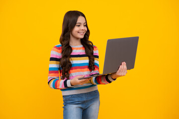 Student teenager schoolgirl with laptop on isolated background. Online webinar, elearning lesson, pc computer. Happy teenager, positive and smiling emotions of teen school girl.