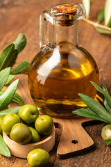 olives and oil. extra virgin olive oil jars on a wooden background. vertical image. place for text