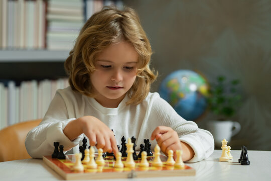 Chess school. Concentrated child play chess. Kid playing board game in classroom.