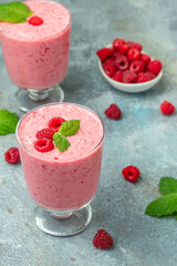 raspberries smoothie milkshake or yogurt in glass jar with berries. Yogurt cocktail on a blue background. place for text, top view