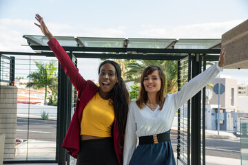 Two young business women celebrate a business success with their arms raised. Concept of...