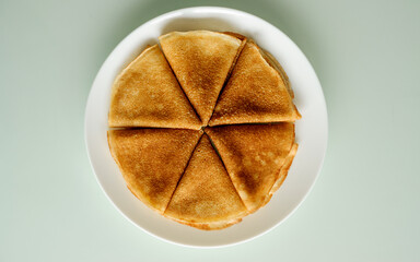 Crepes (Russian Blini) on white plate background, top view. Homemade thin fresh crepes for breakfast or dessert. Maslenitsa