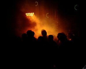 crowd of people dancing and celebrating in a nightclub. the use of dramatic light and a long exposure creates a blured and dynamic image.