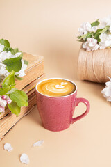 Fototapeta na wymiar Cup of coffee and blossom apple twigs with vinage books. Springtime still life composition
