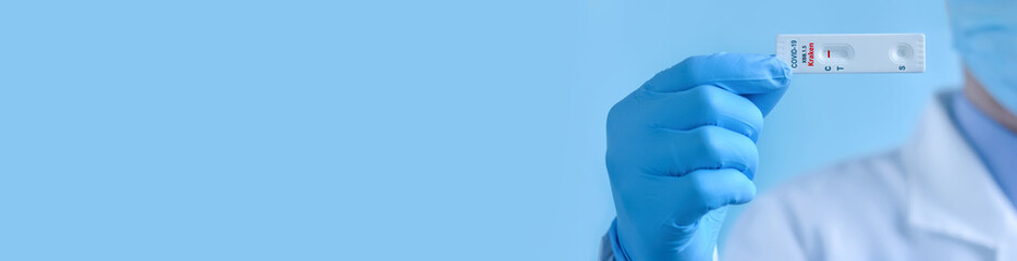 A doctor wearing a protective mask and gloves shows rapid laboratory test for Covid-19 XBB.1.5...