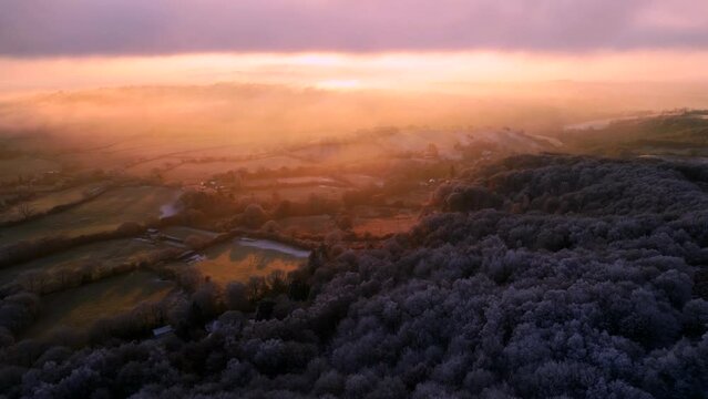 Incredible aerial sunrise view of the Clent Hills in Worcestershire England with frost-covered trees