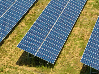 Aerial view of big sustainable electric power plant with many rows of solar photovoltaic panels for producing clean electrical energy. Renewable electricity with zero emission concept